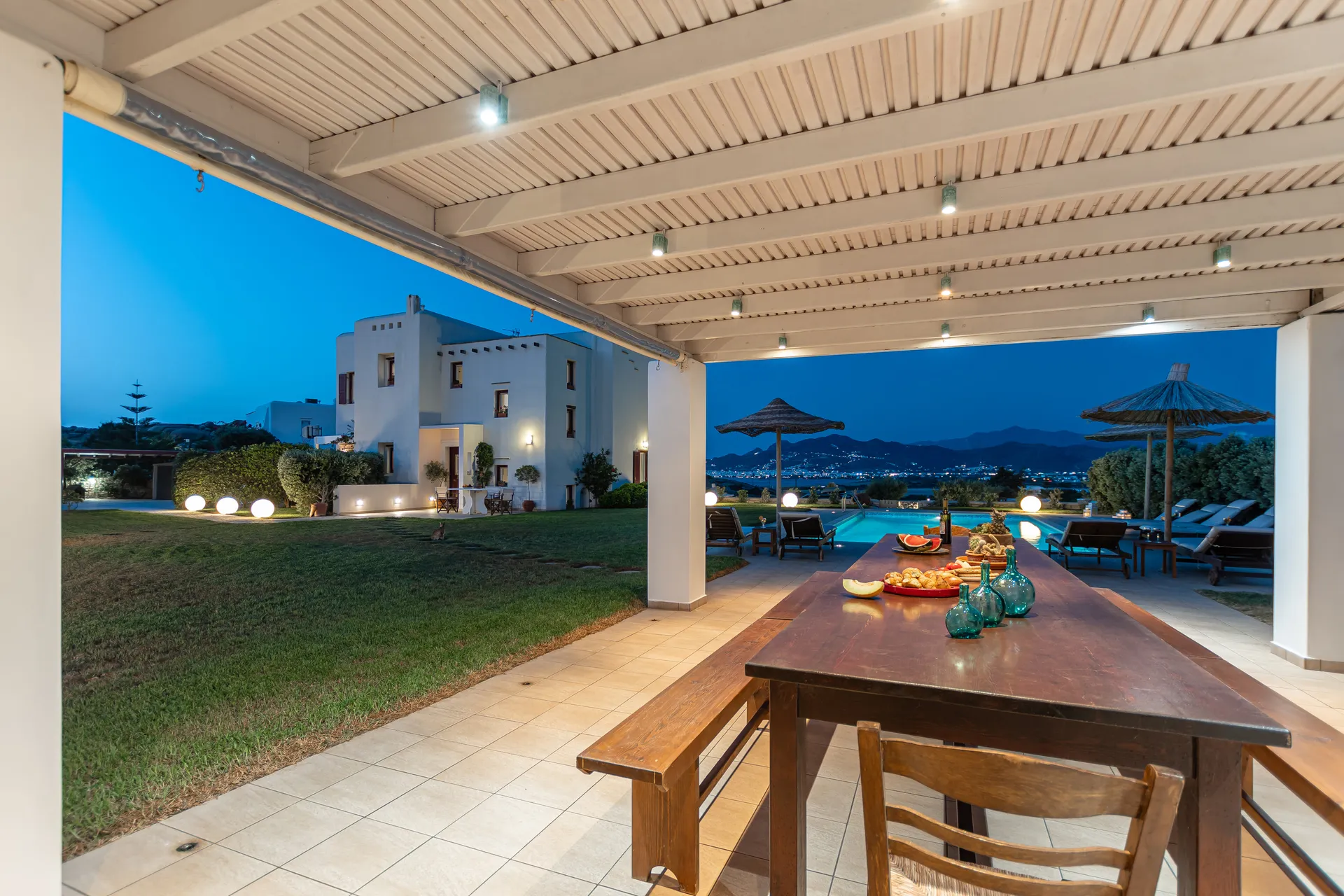The villa has two levels, a swimming pool, and offers a marvelous view of the sea and of Naxos town. Villa I has a private entrance, basketball court and free parking onsite, as well as outdoor showers by the pool. It also has an outdoor barbecue area with a dining table set, where you can enjoy and relax with your friends and family. Villa I is ideal for those who seek a quiet place with privacy. From the fully equipped and functional kitchen to the cozy living area and the large swimming pool you will definitely want to spend as much in-house time as possible with many plants, herbs, and trees that will make your stay a pleasure. A cost-effective holiday option for families with children, groups of friends, or a romantic sanctuary for couples and honeymooners.